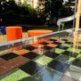 HPL Bench Chess and ludo game s hracou doskou na vonkajšie použitie a oranžovými stolčekmi.