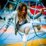 Dievča lezie po Powerclimber climbing net na detskom ihrisku.